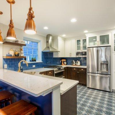 Renovated kitchen with tile floor and copper light fixtures   